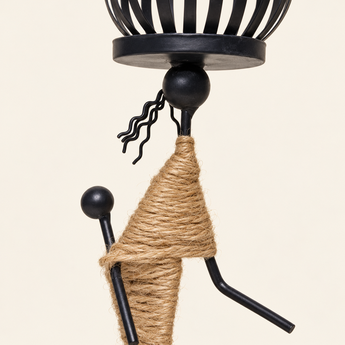 Figure E close detail of black metal, curled wire hair and tan wrapping