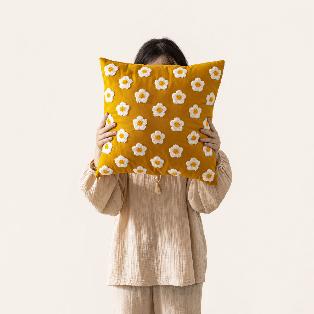 Embroidered Floral Cushion Cover - Yellow Flowers, photographed with source holding hands retained on warm cream